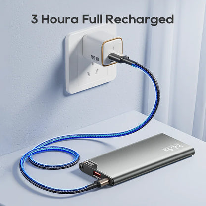 Portable power bank being charged with a cable plugged into a wall socket, text indicating 3 hours of full recharge.