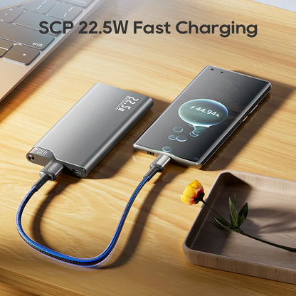 Phone being charged by a power bank on a wooden surface with 'SCP 22.5W Fast Charging' text.